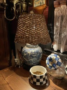 a blue and white vase sitting on top of a wooden table next to a lamp