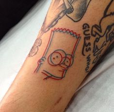 a man with a tattoo on his arm has a cartoon character drawn on the leg