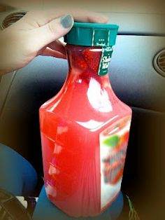 a red plastic bottle sitting on top of a seat in the back of a car