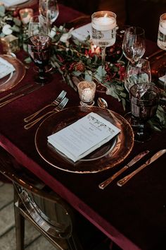 the table is set with place settings and silverware, candles, and napkins