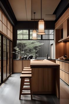 a kitchen with wooden cabinets and stools next to an open floor plan that has sliding glass doors on both sides