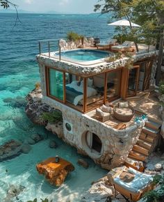 an aerial view of a house on the water with stairs leading up to it's roof