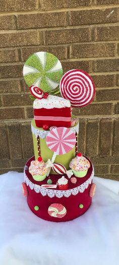 a three tiered cake decorated with candy and lollipops