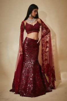 Burgundy mermaid lehenga with an attached cancan and sequins hand embroidery. Comes with a padded blouse and a floral work dupatta.
Components: 3
Pattern: Hand embroidered
Type Of Work: Sequins, Floral
Neckline: Leaf Neck
Sleeve Type: Sleeveless
Fabric: Tulle, Sequins georgette, Buttercrepe
Color: Maroon
Other Details: 
Heavily embroidered blouse
Lehenga length : 45 inches
Occasion: Destination Wedding - Aza Fashions Saree Choli Design, Mermaid Tail Lehenga, Burgundy Bridal Lehenga, Ladies Sangeet Outfit, Red Floral Lehenga, Lehenga Sequins, Sangeet Theme, Mermaid Lehenga, Cocktail Outfits