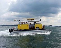 a yellow and white bus driving across the water