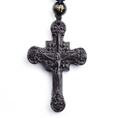 The obsidian beads and pendant come together to complete this all black and natural stone accessory, The pendant features a revised version of the known crucifixion. The engraved piece has different curves and spirals embedded onto it to give it a more tribal aesthetic. However, the cross and the body of our Savior are still clearly defined and set in the black stone. There are various accents around the piece with multiple spirals and dotted features extending from the main cross. The pendant is fairly sized and comes with a macrame rope necklace with large obsidian beads. Another feature of this accessory from Innovato Design are the yellow Chinese characters are painted on to the first bead that is attached to the pendant.  Product Highlights:    Made from Natural Obsidian Stone  Heavil Black Symbolic Cross Pendant Necklace, Black Adjustable Crucifix Necklace, Adjustable Black Crucifix Necklace, Black Spiritual Cross Pendant Necklace, Spiritual Black Cross Pendant Necklace, Black Symbolic Cross Pendant Jewelry, Symbolic Black Cross Pendant Jewelry, Black Engraved Crucifix Necklace, Black Crucifix Necklace Engraved