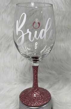 a wine glass with the word bride on it sitting on top of a silver base