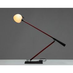 a lamp that is sitting on top of a table in front of a gray wall