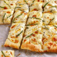 sliced pizza with cheese and herbs on it