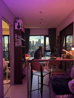 a cat sitting on top of a table in a living room next to a window