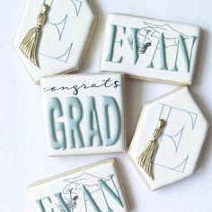 four decorated cookies with graduation letters and tassels on the top one says congrats grad