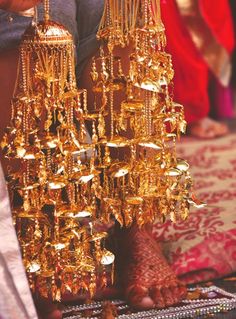 gold jewelry is being sold at a market in india, with people standing around it