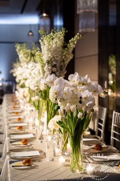 a long table with white flowers in vases