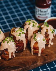 some food is sitting on a wooden board with sauce and ketchup in the background