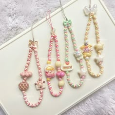 four necklaces are hanging on a white tray