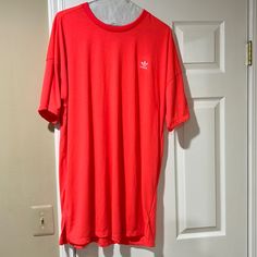 a red adidas shirt hanging on a wall