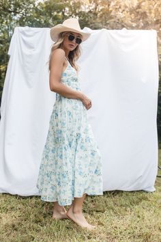 The Saylor Midi Dress features a v neckline, adjustable back tie straps, a tiered skirt and a lining. 100% Cotton Hand Wash Cold, Hang to Dry Blue V-neck Tiered Dress With Ruffle Hem, Flowy V-neck Sundress With Tie Straps, Brunch Maxi Dress With Tie Back And Ruffled Straps, V-neck Midi Dress With Tie Straps For Vacation, V-neck Maxi Dress With Tie Straps For Day Out, Breezy Vacation Dress With Ruffled Straps, Summer Maxi Dress With Tie Back And Ruffled Straps, Garden Party Midi Dress With Adjustable Spaghetti Straps, Sundress With Adjustable Straps And Tiered Shape