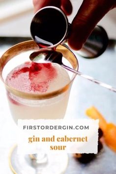 someone is pouring something into a glass with red liquid in it and the words gin and cabernet sour are below