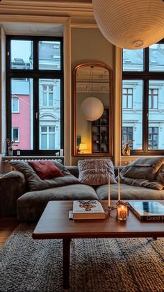 a living room with couches, tables and large windows in front of the window