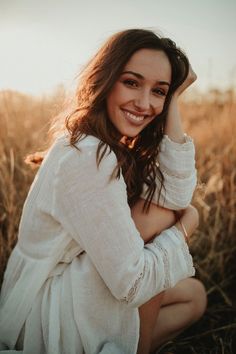 a woman is sitting in the middle of a field