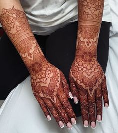 a woman's hands with henna tattoos on them