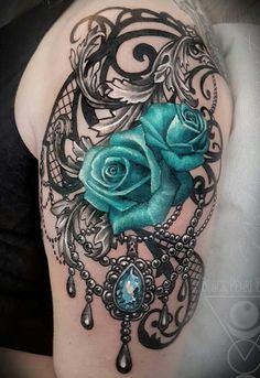 a woman's arm with a blue rose on it and an ornate frame around it