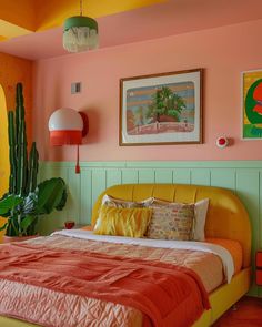 a bedroom with pink walls and yellow bedding in the center is a cactus plant