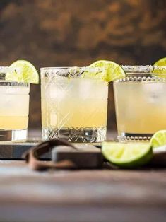 three glasses filled with lemonade and lime slices