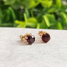 These elegant 14k Yellow Gold Garnet Stud Earrings feature deep red 4.5mm round garnet gemstones, set in classic prong settings with butterfly backs. Perfect for daily wear or special occasions, these gold garnet earrings are a timeless addition to any jewelry collection. The rich hue of the garnet stone combined with the warmth of 14k yellow gold makes these earrings both eye-catching and versatile. Features:      Material: 14k Yellow Gold      Stone: 4.5mm Round Garnet      Weight: 1.4 grams      Closure: Butterfly Backs      Marking: Stamped 14k for authenticity Perfect for: Everyday wear, special occasions, or as a meaningful birthstone gift Ideal Gift: For birthdays, anniversaries, or for garnet lovers  The garnet is known as a symbol of love and passion, making these earrings a perfe Fine Jewelry Garnet Round Earrings, Round Garnet Earrings Fine Jewelry, Garnet Fine Jewelry Earrings, Garnet Round Earrings For Anniversary, Round Garnet Earrings For Anniversary, Anniversary Garnet Round Earrings, Garnet Earrings For Anniversary, Classic Round Garnet Earrings, Yellow Gold Garnet Round Earrings