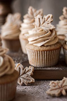 some cupcakes with frosting and leaves on them