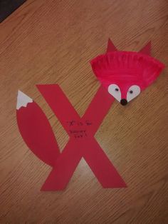 a paper plate shaped like a fox with the letter x cut out on it's side