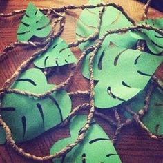 some paper leaves are tied together on a wooden table with rope and twine around them