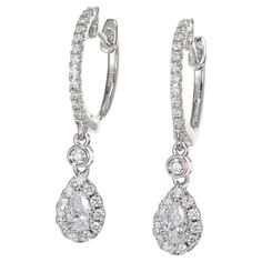 Diamond dangle hoop earrings. These simple but elegant earrings are made up of 2 pear shape diamonds totaling .24cts, each with a halo of round cut diamonds, connected to lever back hoop by a single bezel set round diamond. Both the fronts of each hoop is adorned with round cut diamonds. Designed and crafted in the Peter Suchy Workshop. 2 pear shape diamonds, G-H SI approx. .24cts 48 round diamonds, G-H VS SI approx. .50cts 18k white gold Stamped: 18k 750 2.9 grams Top to bottom: 25mm or 1 Inch Width: 5.5mm or .21 Inches Depth or thickness: 3.6mm Please Note, we photograph each item as accurately as possible. However due to monitor/mobile device resolution and calibration, we understand some photos may vary in appearance. If you are not satisfied and offer a 30 day full money back return p Pear Halo, White Gold Hoops, Dangle Hoop Earrings, Pear Diamond, Pear Shaped Diamond, Gold Hoop, Elegant Earrings, Round Cut Diamond, Pear Shaped