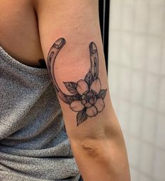 a woman's arm with a flower and an umbrella tattoo on her left arm