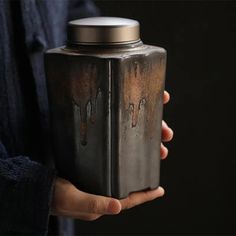 a person holding a metal container in their hand