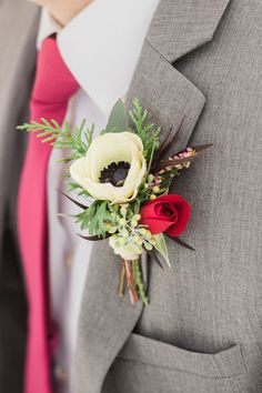 a man wearing a suit and tie with a boutonniere on his lapel