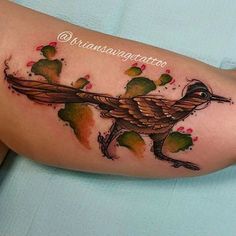 a bird tattoo on the arm with cactuses around it and watercolors in the background