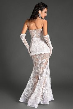 the back of a woman wearing a white dress with sheer lace and long gloves on it