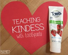 a tube of toothpaste next to a heart shaped paper with the words teaching kindness written on it