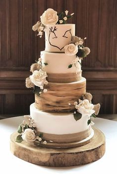 a three tiered wedding cake with flowers on top