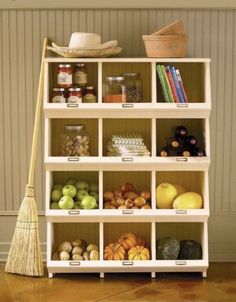 a shelf filled with lots of different types of fruits and vegetables next to a broom