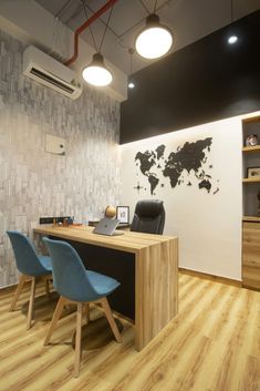 an office with wood flooring and white walls, two blue chairs are in front of the desk