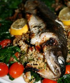 a white plate topped with fish and vegetables