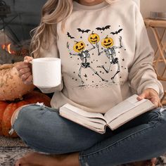 🎃 Get into the Halloween spirit and Pumpkin Season with this adorable and spooky Retro Halloween sweatshirt! Featuring two retro-style dancing skeletons with jack-o'-lantern heads, this cute fall sweater is the perfect addition to your spooky season wardrobe. Whether you're heading to a Halloween party, looking for a casual Halloween costume, or just love to celebrate the spooky vibes, this Halloween sweater is a must-have. Made from a soft, cozy Gildan Sweaters, this crewneck is designed for ultimate comfort while keeping you stylishly spooky. The playful design, complete with flying bats and a vintage-inspired print, makes it a standout piece for any Halloween celebration. Ideal for all the Halloween-loving mamas out there, this "Stay Spooky" shirt is perfect for those chilly autumn day Fun Halloween Crew Neck Sweatshirt, Funny Crew Neck Sweatshirt For Halloween, Casual Halloween Costumes, Casual Halloween Outfits, Retro Dancing, Cute Fall Sweater, Skeletons Halloween, Cute Sweaters For Fall, Halloween Party Costume