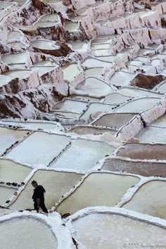 a man standing in the middle of an open area with snow on it's ground