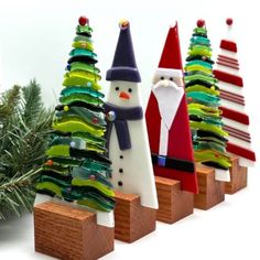 small christmas trees with santa and snowmen on them in front of a white background