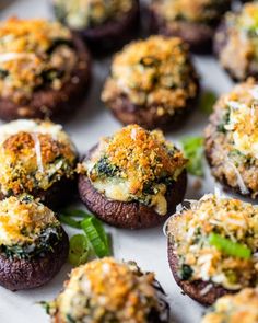 small stuffed mushrooms with cheese and spinach sprinkled on top are ready to be eaten