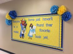 a bulletin board with blue pom poms hanging on it's wall in a classroom