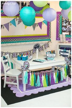 a table with some decorations on it and paper lanterns hanging from the ceiling over it