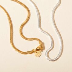 Embrace the elegance of our Snake Chain Necklace, a staple piece to add sophistication to every look. Perfect for wearing alone or for layering alongside your favourite Merci Maman personalized necklaces, this chain is a timeless way to elevate your everyday jewelry collection.&nbsp;18K Champagne Gold Plated or 925 Sterling SilverLength: 0.4Width: 0.09Thickness: 0.05Sent with love in a complimentary gift box Classic Charm Necklace With Delicate Chain For Everyday, Everyday Timeless Necklace With Delicate Chain, Timeless Cable Chain Necklace With Round Pendant, Minimalist Charm Necklaces With Gold Chain For Layering, Minimalist Gold Chain Charm Necklace For Layering, Timeless Charm Necklace With Adjustable Chain For Everyday, Classic Yellow Gold Snake Chain Necklace With Adjustable Chain, Classic Tarnish-resistant Chain Necklace With Round Pendant, Elegant Tarnish Resistant Initial Pendant Chain Necklace